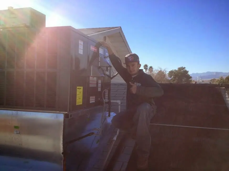HVAC technician performing Boiler Repair on a rooftop unit in Cornelius